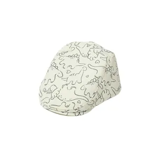 Béret enfant beige avec motifs de dinosaures noirs sur un fond blanc impeccable