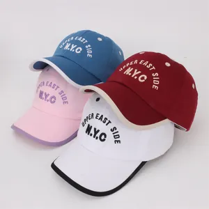 Kids NYC baseball caps in blue, red, pink, and white with Upper East Side embroidery