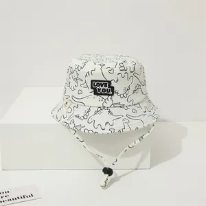 Detail of baby sun hat with dinosaur patterns and LOVE YOU patch plus adjustable chin strap