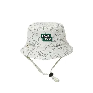 White baby sun hat with black dinosaur print and LOVE YOU patch, includes chin strap