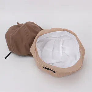 Détail du béret pour bébé montrant la doublure en coton et la broderie moco noire