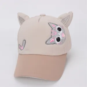 Detail of cute cat ears and embroidered face on children beige baseball cap with pink glitter