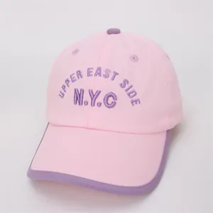Detail of pink canvas kid's baseball cap with purple NYC embroidery and contrast brim