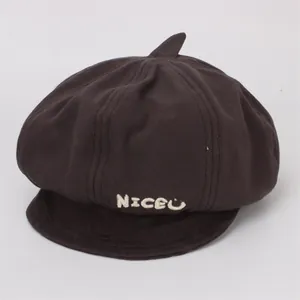 Détail du béret en coton marron foncé avec broderie blanche NICEU et texture fine