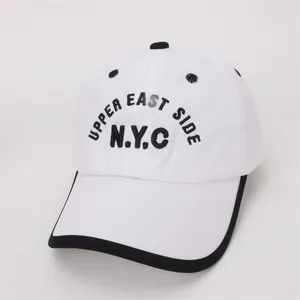 Close-up of NYC Upper East Side embroidery on children's white cotton baseball cap