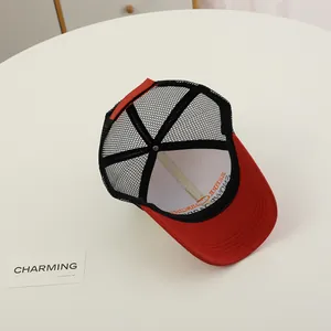 Detail view of red and black mesh trucker cap with breathable back and interior printing