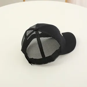 Detail of children's breathable black mesh trucker hat with side embroidery and curved brim