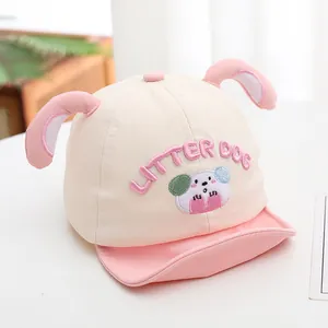 Detail of baby baseball cap featuring cartoon dog embroidery and 3D bunny ears on top