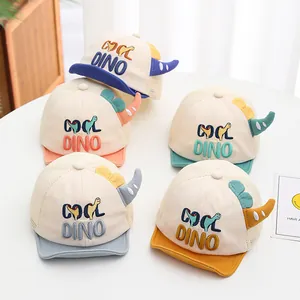 Detail of baby mesh caps with COOL DINO embroidery and 3D colorful dinosaur horns