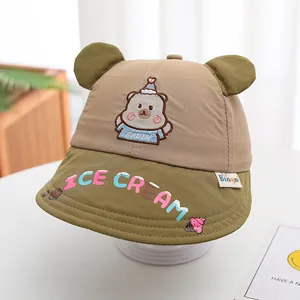 Détail de la broderie d'ours et oreilles 3D sur un chapeau soleil kaki et vert enfant