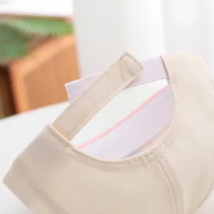 Detail of adjustable Velcro strap on beige cotton baby baseball cap with fine stitching