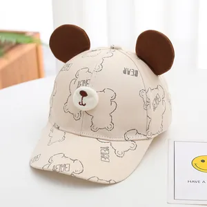 Détail d'une casquette de baseball beige pour bébé avec oreilles 3D et broderie d'ours