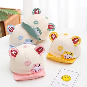 Detail of four cartoon baby baseball hats in pink, yellow, green and blue with animal ears