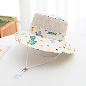 Detail of baby sun hat featuring breathable mesh, cartoon dinosaur print and chin strap