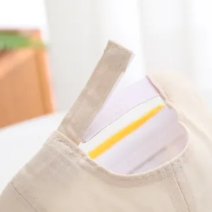 Detail of adjustable Velcro strap on baby baseball cap made of premium beige cotton twill