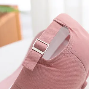 Pink baseball cap back view showing adjustable metal buckle and twill fabric detail