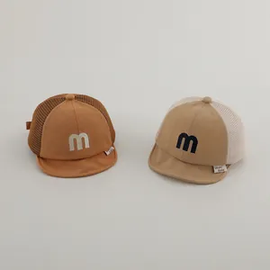 Detail of mesh baby baseball caps in brown and khaki with soft brim and M embroidery
