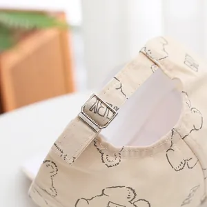 Détail de la boucle métallique réglable et des coutures sur la casquette beige enfant