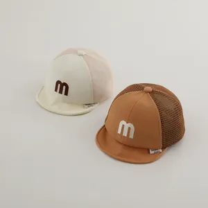 Close-up of baby mesh baseball caps with M embroidery and breathable fabric detail