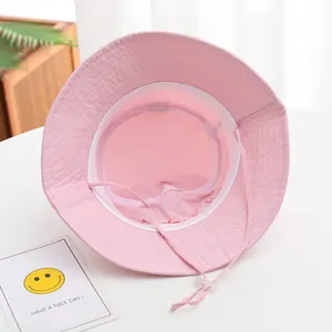 Detail of pink cotton baby sun hat showing adjustable chin strap and interior lining