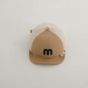 Detail view of khaki baby mesh cap featuring 3D blue letter m embroidery and breathable mesh