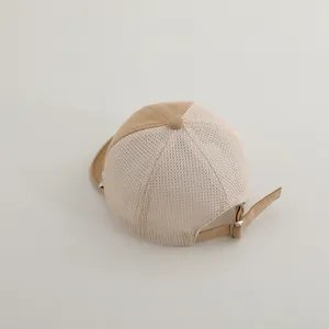 Detail of breathable mesh fabric and adjustable metal buckle on kids' baseball cap