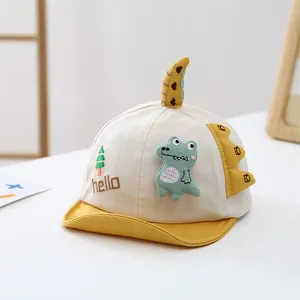 Détail d'une casquette bébé dinosaure avec pointes 3D et broderie hello mignonne