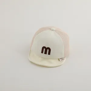 Detail of baby baseball cap featuring pink breathable mesh and brown letter m embroidery