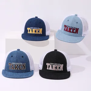 Close-up of four mesh trucker hats with denim fronts and TAKEN letter embroidery