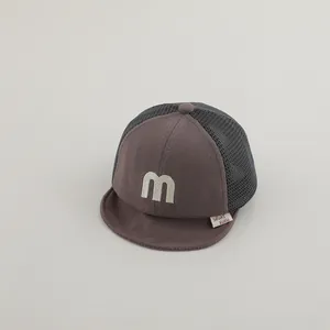 Close-up of baby mesh baseball cap with white letter m embroidery and soft brim detail
