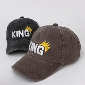 Detailed macro view of 3D KING embroidery and crown on washed cotton baseball caps