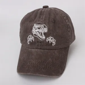 Gros plan d'une casquette de baseball vintage marron avec broderie de dinosaure