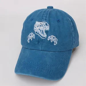 Détail de la broderie dinosaure sur casquette en coton délavé avec coutures nettes