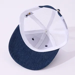 Detail of blue denim trucker hat with white mesh back and adjustable metal buckle