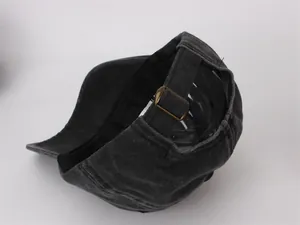 Detail of adjustable brass metal buckle on vintage washed cotton military flat top cap