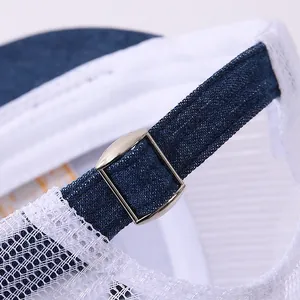 Detail of adjustable silver metal buckle and mesh fabric on a blue kids hip-hop cap