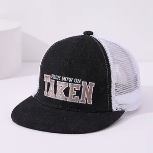 Close-up of TAKEN embroidery on breathable mesh truck cap for kids in black and white