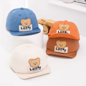Japanese style baby baseball caps in four colors featuring a cute plush bear and Lucky label