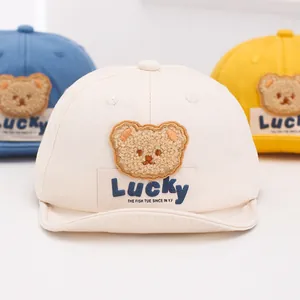 Detail of baby soft baseball caps featuring plush bear embroidery and Lucky label design
