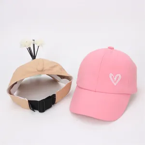 Vue détaillée de chapeaux de soleil rose et beige avec broderie cœur et sangle réglable