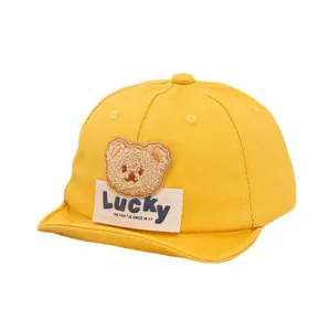 Cute yellow cotton baby baseball cap featuring a plush bear patch and Lucky label