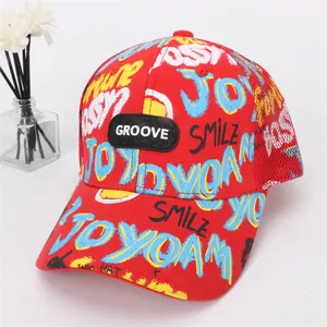 Dettaglio del berretto rosso in mesh con stampe graffiti e logo nero GROOVE