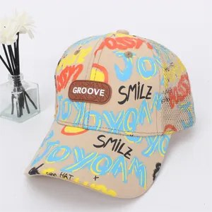 Dettaglio cappellino bambino con stampa graffiti, rete traspirante e logo in gomma