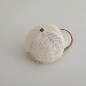 Détail de la maille respirante et du bord marron sur la casquette de baseball beige enfant