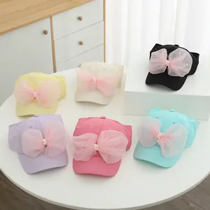 Detail view of summer sun hats for girls featuring large mesh bows and pearl centers