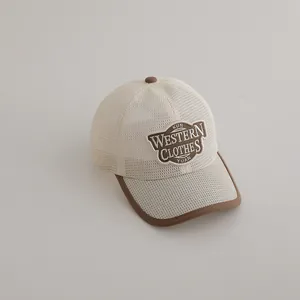 Détail du tissu en maille respirante et de la broderie sur la casquette marron enfant