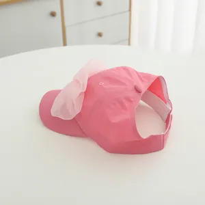 Detail of a pink sun hat for girls featuring a large organza bow and ponytail opening