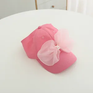 Close-up of pink sun hat featuring a large organza bow and delicate pearl embellishments