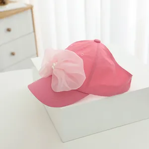 Detail of pink girls sun visor hat featuring a large organza bow and pearl accents
