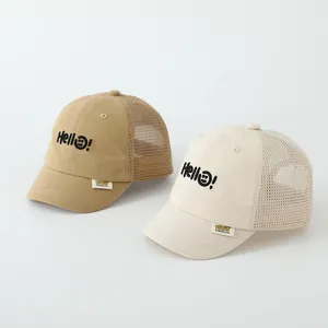 Detail view of khaki and beige mesh baby caps with Hello embroidery and smiling face